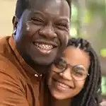 Father hugging daughter, both smiling