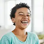 Boy with hat and braces smiling