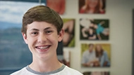 Teenage boy with dental braces smiling, displaying a happy and confident expression.