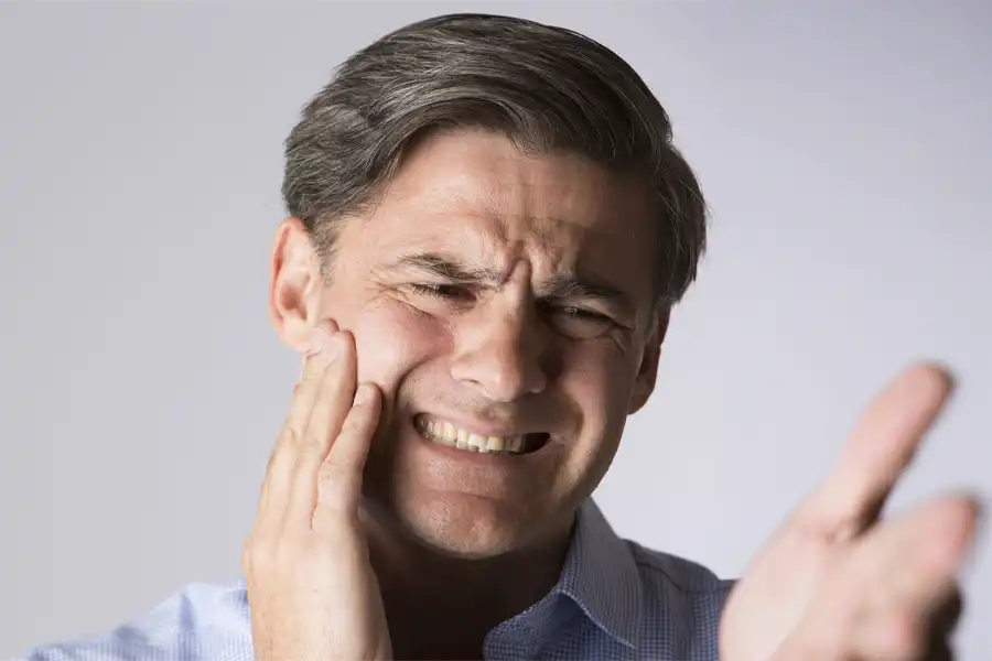 Man with tooth pain grimacing