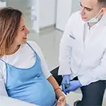 Dental professional talking to pregnant patient
