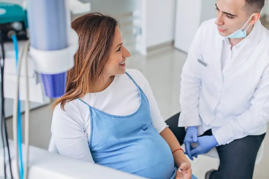 Dental professional talking to pregnant patient