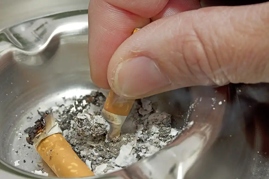 Man putting out his cigarette in an ashtray
