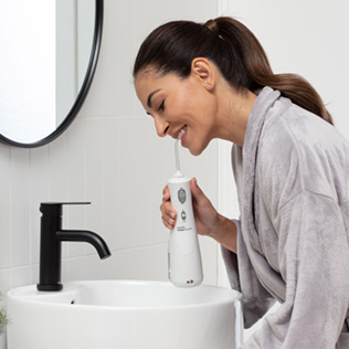 Woman using the WP-450 Cordless Advanced Water Flosser