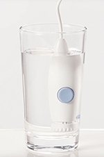 Countertop Water Flosser handle soaking in white vinegar and water mixture