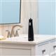 Black Cordless 1100 handheld water flosser on a bathroom sink.