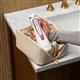 Rose Gold Cordless Advanced 2.0 handheld water flosser, without tip, taken out of a toiletry bag.