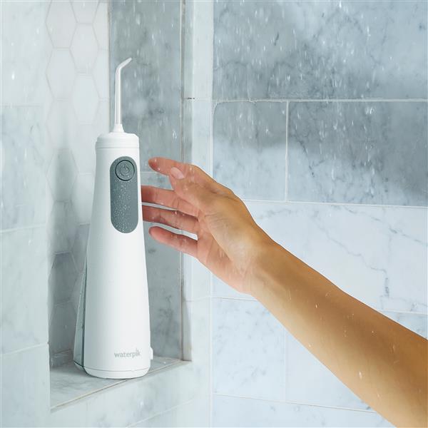 White Cordless Enhance 3200 handheld water flosser with retail packaging.