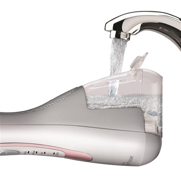 Filling the water reservoir of the rose gold Cordless Advanced 2.0 handheld water flosser.