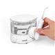 White ION countertop water flosser, with hand holding the handle and attached tip to place in magnetic handle cradle.