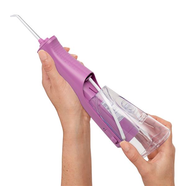 Sliding the water reservoir to remove it from the mauve Cordless Pulse 3100 water flosser handle.