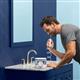 White ION countertop water flosser in use, with person leaning over the bathroom sink.