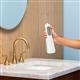 White Cordless Enhance 3200 handheld water flosser held vertically above bathroom sink.