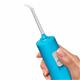 Cyan Cordless Pulse 3100 handheld water flosser handle and tip, shown held in a hand for scale.