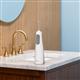 White Cordless Enhance 3200 handheld water flosser on a bathroom sink.